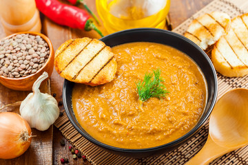 Cream soup made of lentil and vegetables on table with ingredients, healthy food, top view