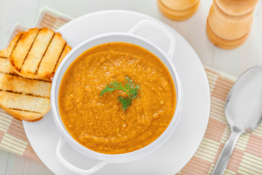 Bowl of lentil cream soup on table for healthy lunch, top view