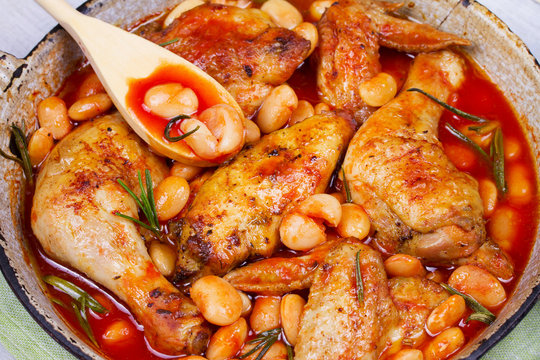 Chicken with white beans and rosemary in pan