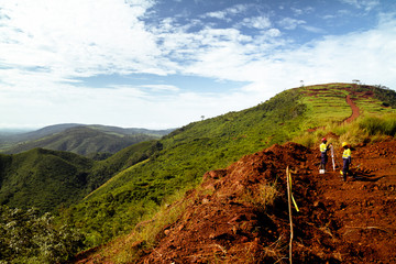 Mining construction workers surveying mountain top in Africa