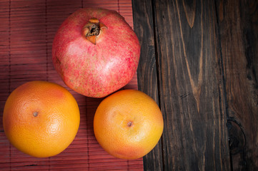 pomegranate and grapefruit. Fresh fruit. Fruit variety on wood. Food background.