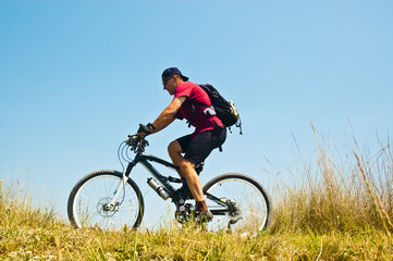 Fototapeta na wymiar Bicycler against blue sky