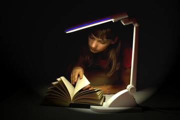 Little girl and book under lamp