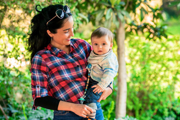 Mother holding her son outside in nature