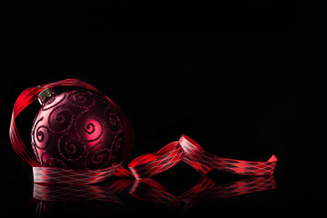 Red christmas ball on black background