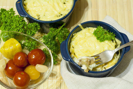Julienne with mushrooms and cream. Mushroom and cheese gratin in ceramic bowls, on wooden background