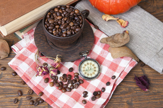Wooden cup with coffee and grinder on the autumn background
