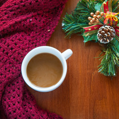 Cup of hot coffee with Christmas decoration and scarf