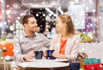 happy couple with shopping bags drinking coffee