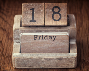 Grunge calendar showing Friday the eighteenth on wood background