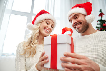 happy couple at home with christmas gift box