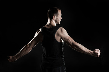 muscular man,  black background, place for text on the right