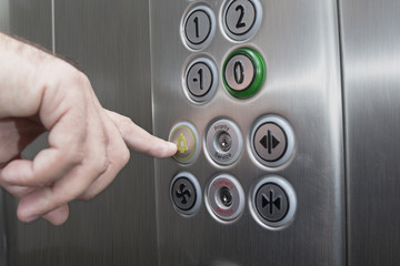 Forefinger pressing the alarm button in the elevator © zphoto83