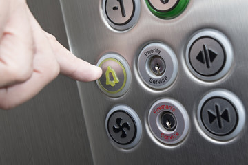 Forefinger pressing the alarm button in the elevator © zphoto83