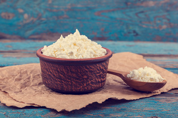 Fresh cottage cheese in a ceramic dish and spoon