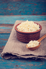 Fresh cottage cheese in a ceramic dish and spoon