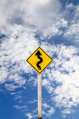 Curvy Road Sign on blue sky background with clipping path.