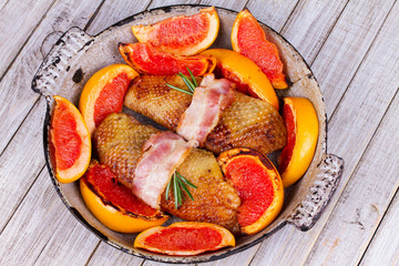 Roasted duck breast fillet with bacon, grapefruit and rosemary. View from above