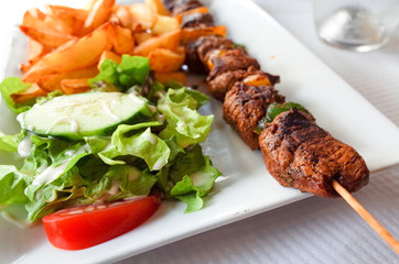 tasty grilled meat and vegetables skewers on a slate plate