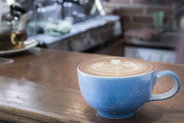 Close up blue cup of Coffee, latte on the wooden table