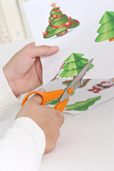 close-up on the hands of a woman taking a picture of a Christmas decoration pattern