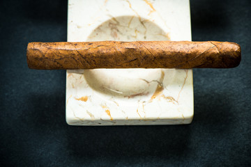 Cuban cigar in marble ash tray