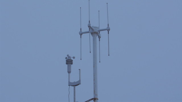 An anemometer on a tower in a small port. An anemometer is a device used for measuring wind speed and is a common weather station instrument.