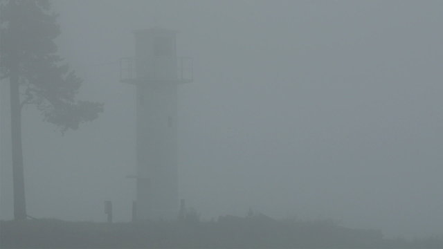 The lighthouse on the small port in a town. The lighthouse helps the ship to dock during night time