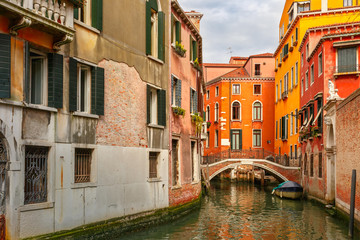 Fototapeta na wymiar Colorful lateral canal and bridge in Venice, Italy
