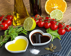 Oil and vinegar in heart shaped bowls with fresh produce