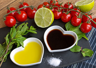 Oil and vinegar in heart shaped bowls with fresh produce