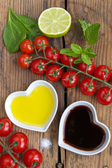 Oil and vinegar in heart shaped bowls with fresh produce