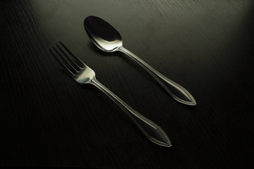 fork and spoon on a black table