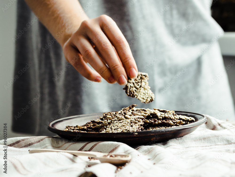 Wall mural crackers from flax seed, sesame, sunflower and spices on a dark