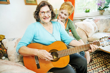 Seniorin spielt Gitarre für ihre tochter