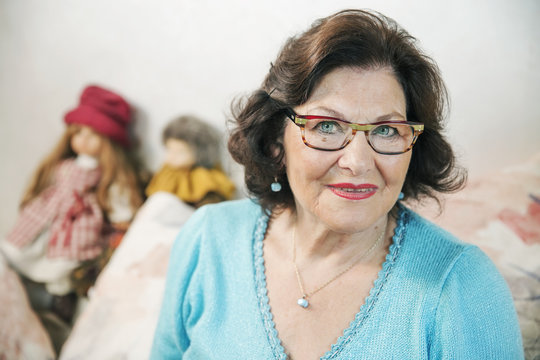 Seniorin auf dem Sofa mit Puppen, Portrait