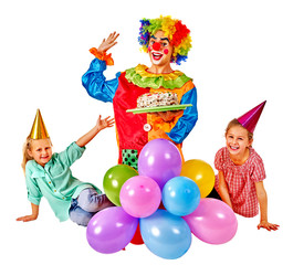 Clown holding cake on birthday with group children.