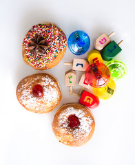 Fresh donuts and colorful dreidels for Hanuka Jewish Holiday. View from above.