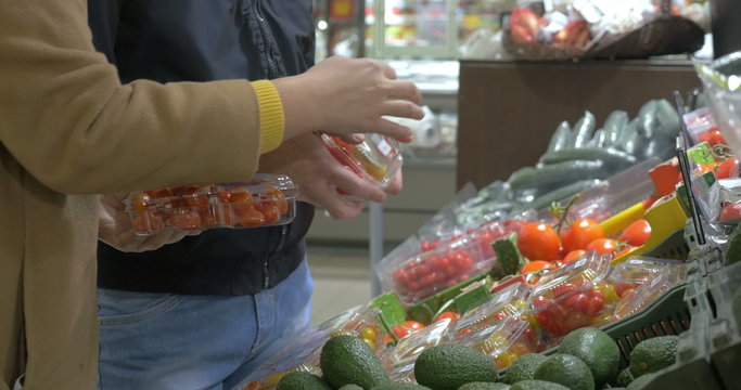 Customers choosing tomatoes in the supermarket