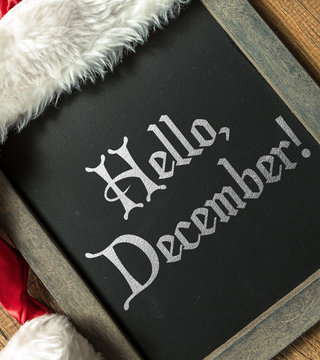 Hello, December! written on blackboard with santa hat