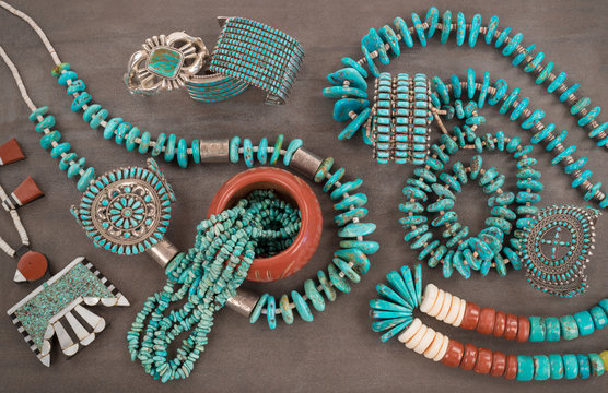 Collection of Vintage Native American Jewelry . A Santo Domingo “Depression Era” Necklace, and Turquoise "Nugget" necklaces with silver beads, and Zuni and Navajo Bracelets, Grey Slate Background.