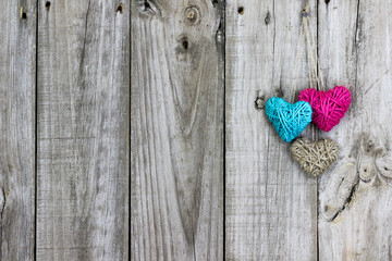 Three rope hearts hanging on antique rustic wood door