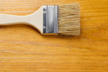 Paint brush on varnished wooden board with place for text