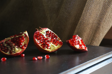 Pomegranate on wooden table and golden textile on background