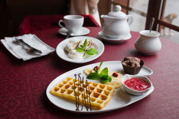 Belgian wafers with hot chocolate, strawberry sauce and ice cream