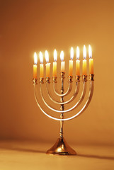 Brightly Lit Hanukkah Menorah on a Warm Gold Background