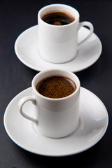 Cups of coffee over the black background