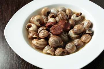 white dish with snails cooked in sauce