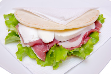 Flatbread with ham and mozzarella cheese on white background close up view