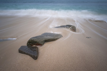 wave and stone in sea (slow shutter)